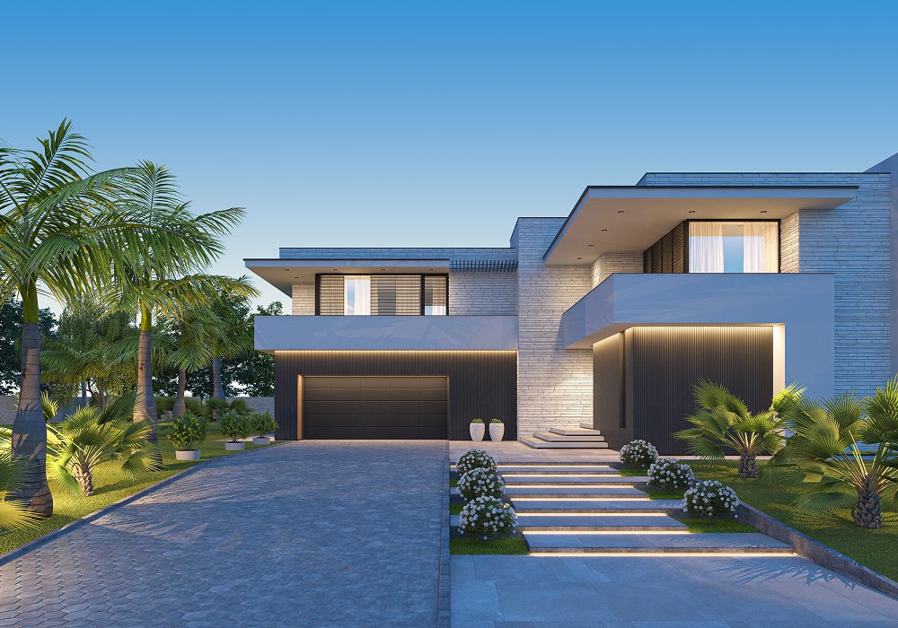 Modern house with a driveway in front of it, surrounded by lush green grass, plants, and trees